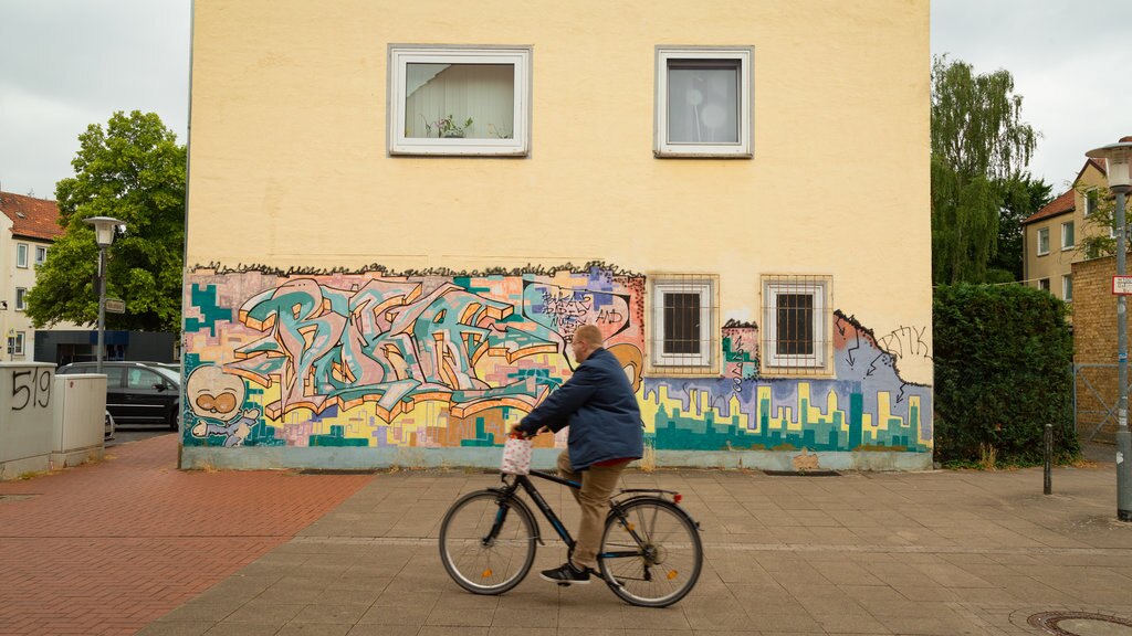 Mittelfeld mostrando ciclismo urbano e arte ao ar livre assim como um homem sozinho