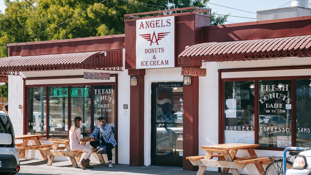 Alberta Street mostrando jantar ao ar livre e sinalização assim como um casal