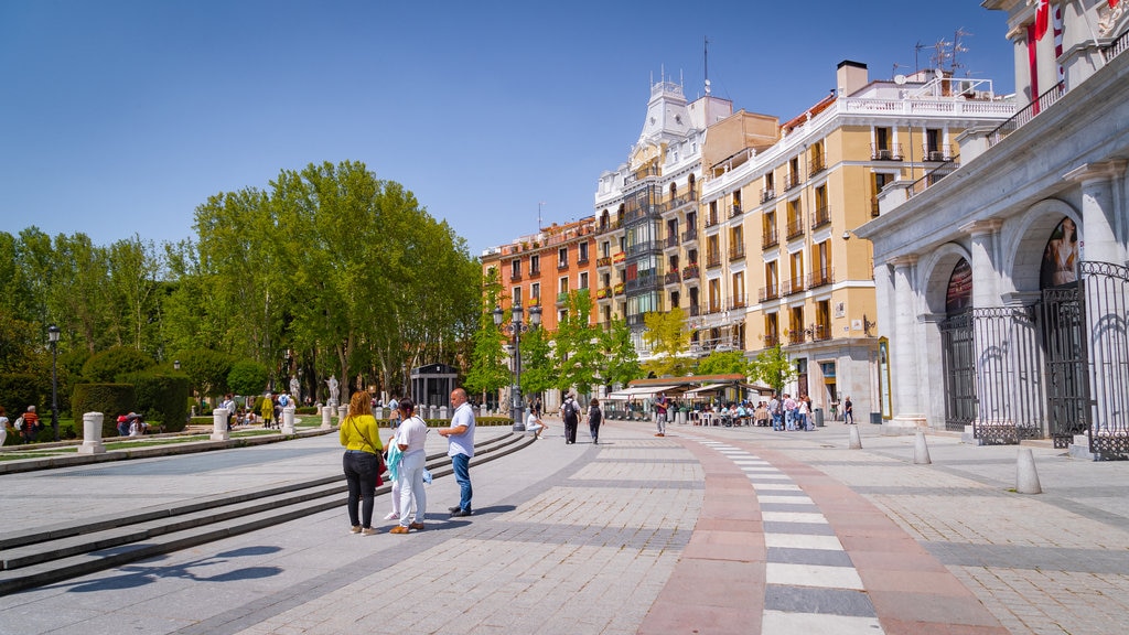 Plaza de Oriente que inclui cenas de rua assim como um pequeno grupo de pessoas