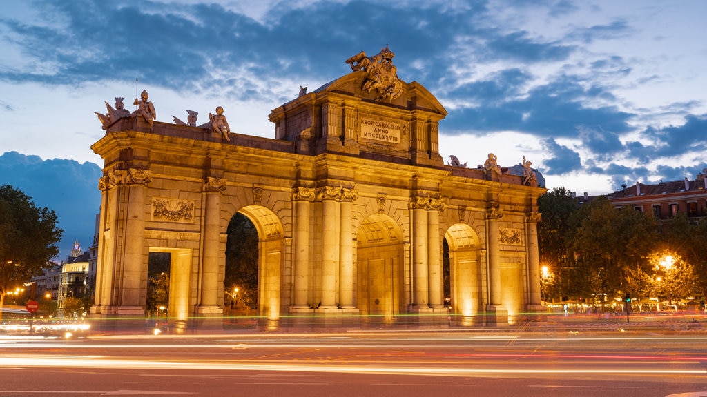 Puerta de Alcalá que incluye escenas de noche y arquitectura patrimonial