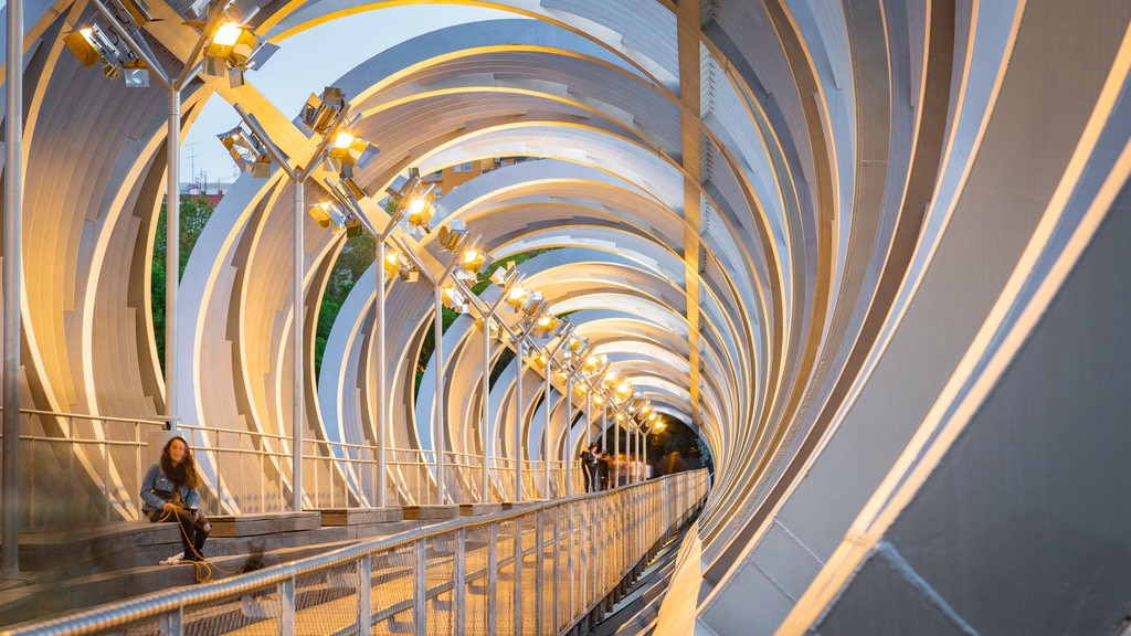 Puente monumental del parque de Arganzuela ofreciendo un atardecer y un puente y también una mujer