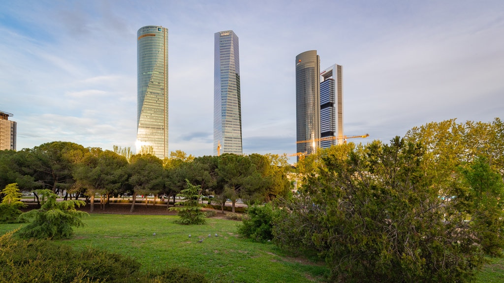 Área comercial Cuatro Torres Business Area ofreciendo un edificio alto y un parque