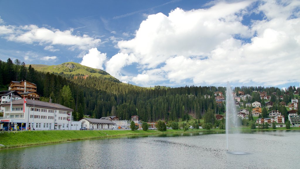 Arosa ofreciendo una pequeña ciudad o aldea, un lago o espejo de agua y una fuente