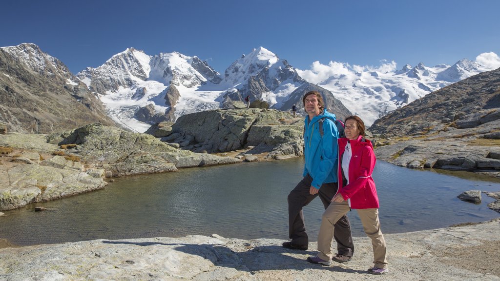 St. Moritz ofreciendo senderismo o caminata y un lago o abrevadero y también una pareja