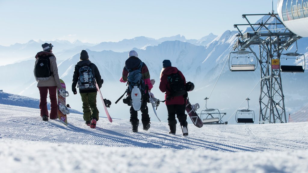 Laax Ski Resort mostrando snowboard e neve assim como um pequeno grupo de pessoas