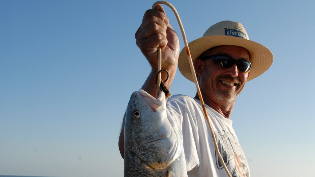 Port Aransas featuring fishing and food as well as an individual male