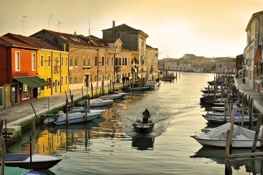 Un uomo in barca lungo un canale di Murano - Photo credit Shutterstock