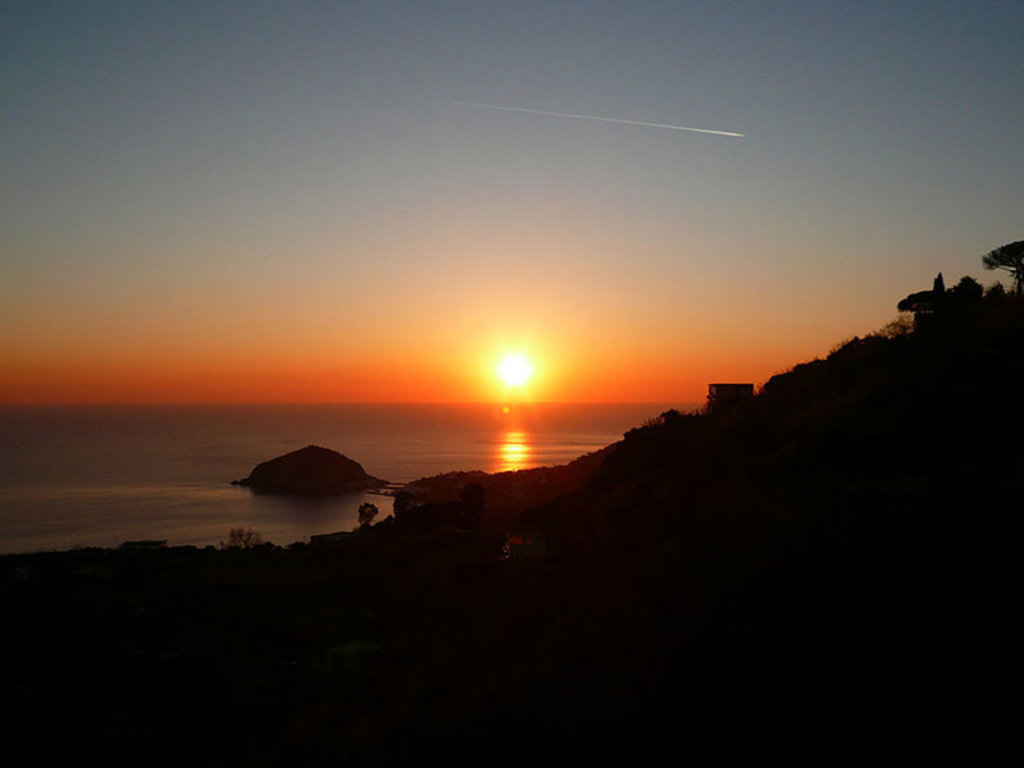 Tramonto da Barano d'Ischia. Ben visibile la sagoma dell'isolotto di Sant'Angelo, il punto più meridionale dell'isola. By Dr.Conati Roberto De Martino (Own work)  , via Wikimedia Commons.