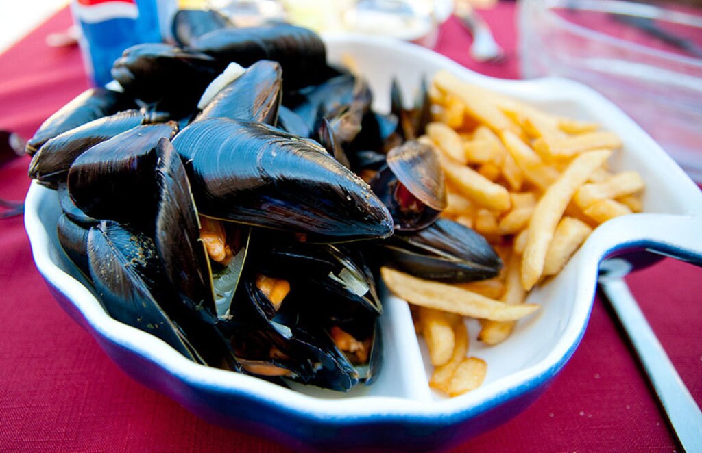 Le famose moules et frites. By Archangel12 (Normandy '10: Grandcamp Maisy La Belle Mariniere)  , via Wikimedia Commons