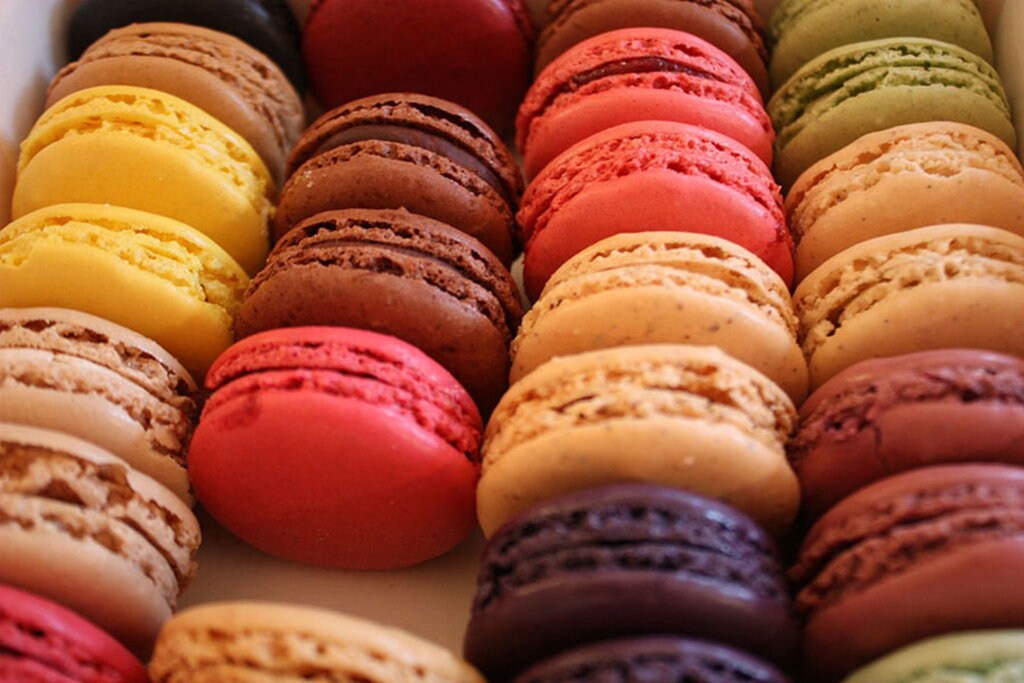 I macarons sono pasticcini di meringa colorata con un cuore di ganache; i migliori sono quelli da Ladurée. Di Sunny Ripert  , attraverso Wikimedia Commons 