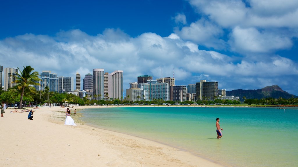 Ala Moana Beach Park som viser tropiske områder, svømning og moderne arkitektur