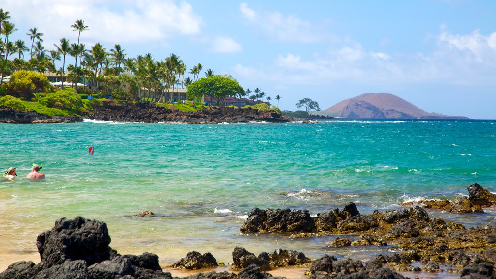 Wailea Beach som inkluderar bad, landskap och en stenstrand