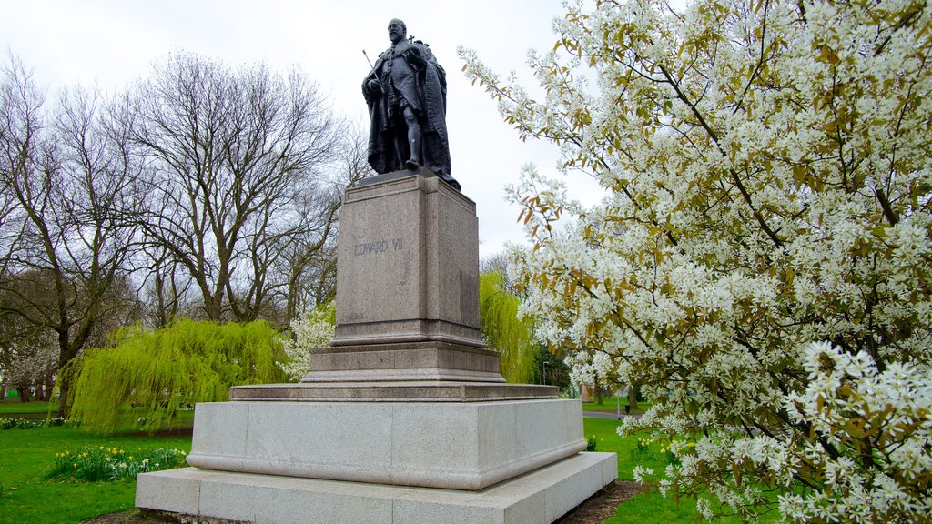 Whitworth Art Gallery que incluye un monumento, flores y una estatua o escultura