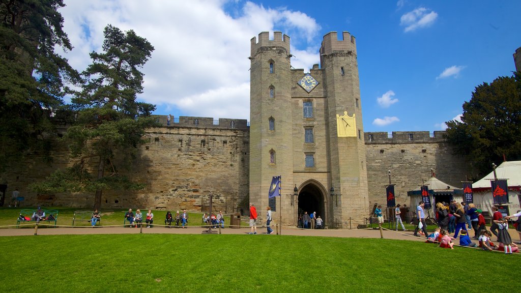 Warwick Castle which includes heritage architecture and château or palace as well as a large group of people