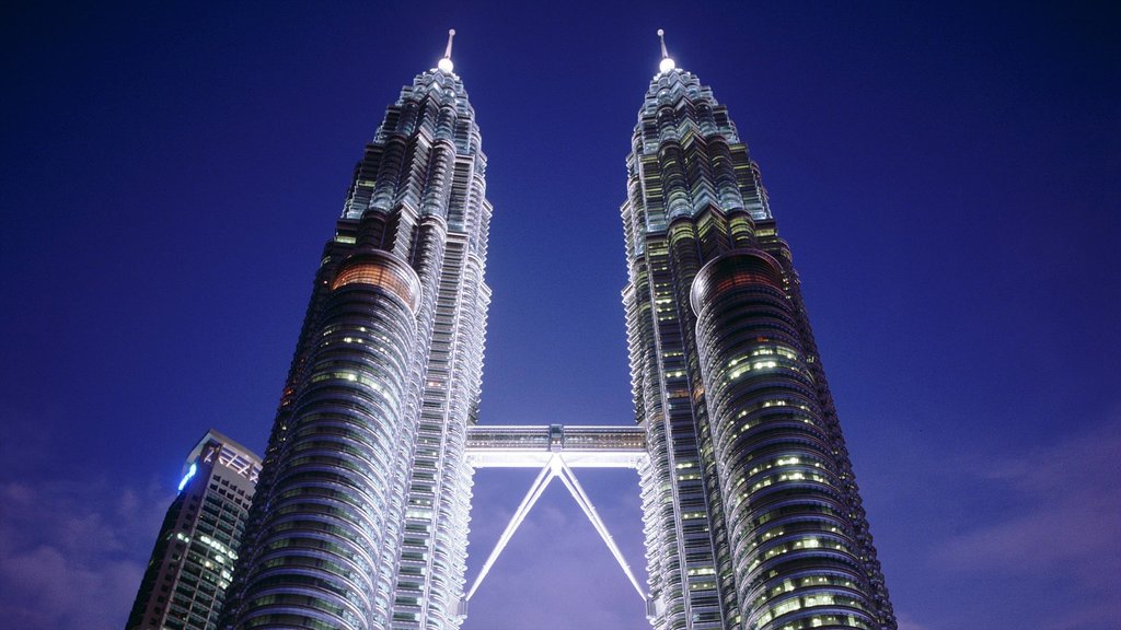 Petronas Twin Towers que inclui arquitetura moderna, um arranha-céu e cenas noturnas