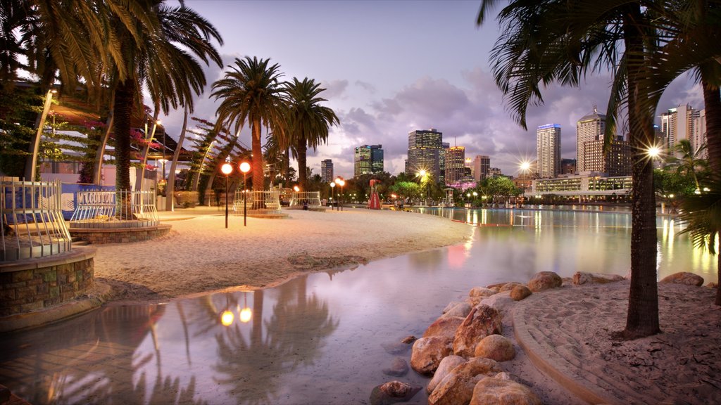 Southbank Parklands which includes tropical scenes, a sandy beach and a bay or harbour