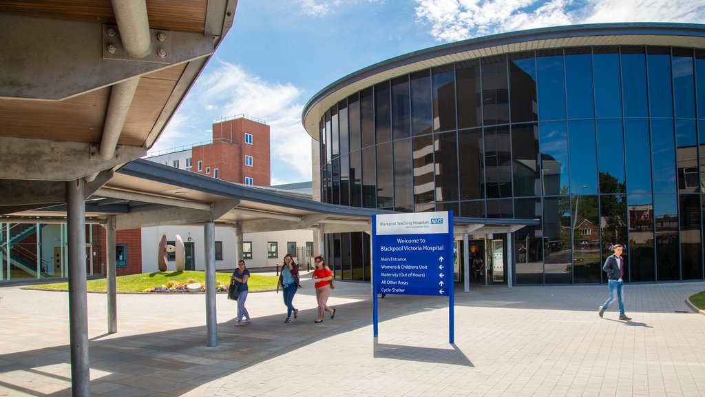 Victoria Hospital featuring street scenes and signage as well as a small group of people