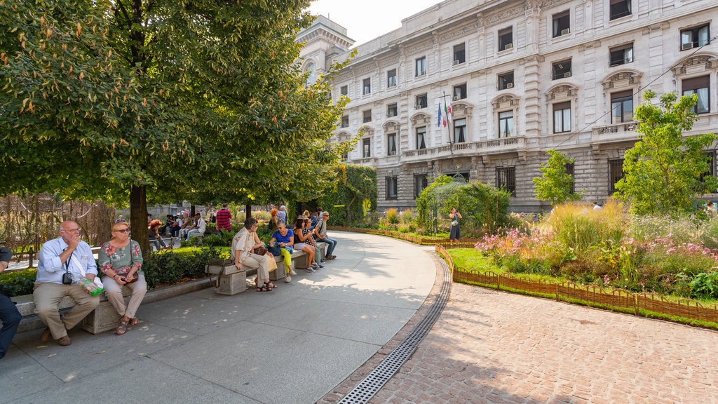 Piazza della Scala mostrando un jardín y también un pequeño grupo de personas