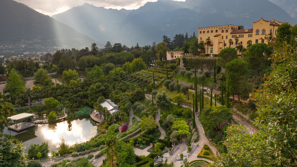 Jardines del castillo de Trauttmansdorff ofreciendo un atardecer, vista panorámica y una pequeña ciudad o aldea