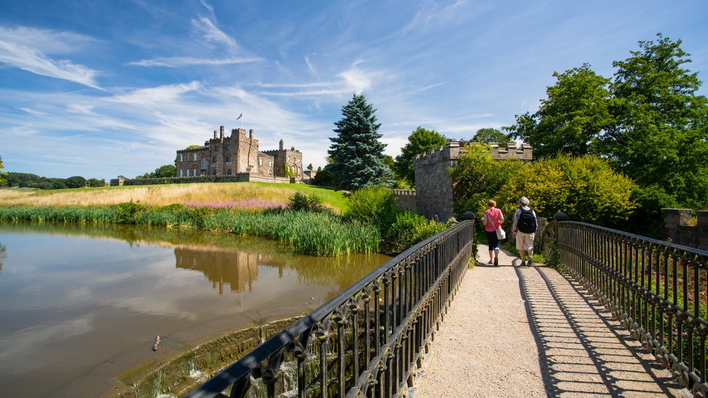 Ripley Castle and Gardens showing a lake or waterhole and a bridge as well as a couple