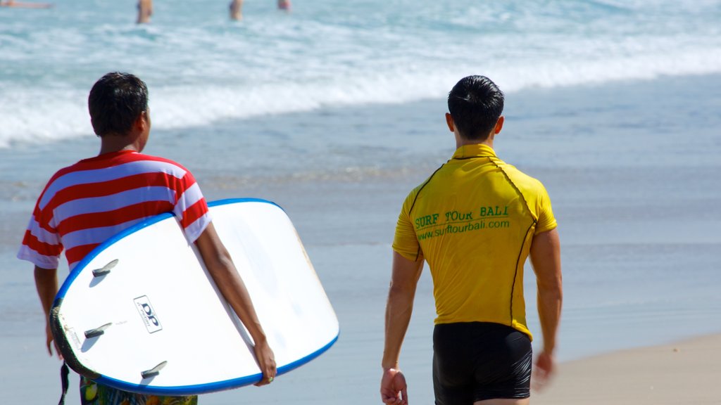 Kuta Beach which includes a beach and surfing as well as a small group of people