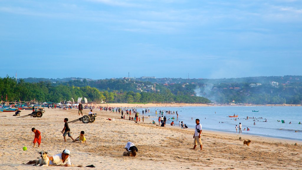 Jimbaran Beach which includes a sandy beach as well as a large group of people