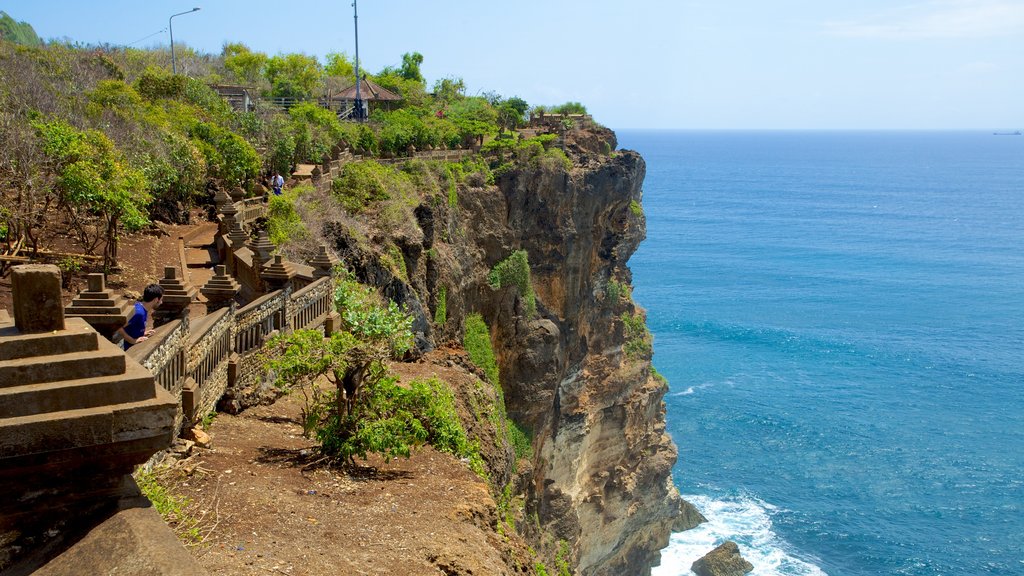 Uluwatu Temple featuring landscape views, rocky coastline and a temple or place of worship