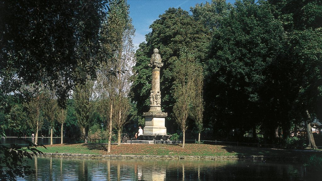 English Garden which includes a lake or waterhole, a garden and a monument