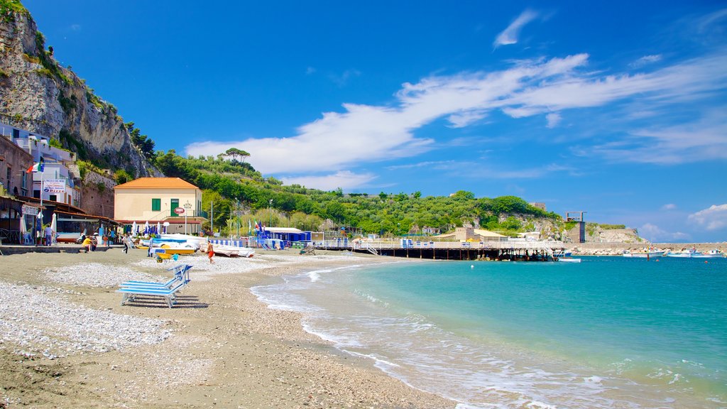 Marina di Puolo mostrando una bahía o puerto, una ciudad costera y una playa de guijarros