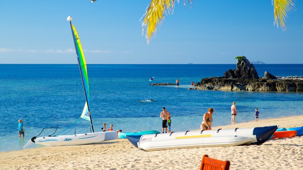 Isla Castaway ofreciendo una playa de arena y deportes acuáticos y también un gran grupo de personas