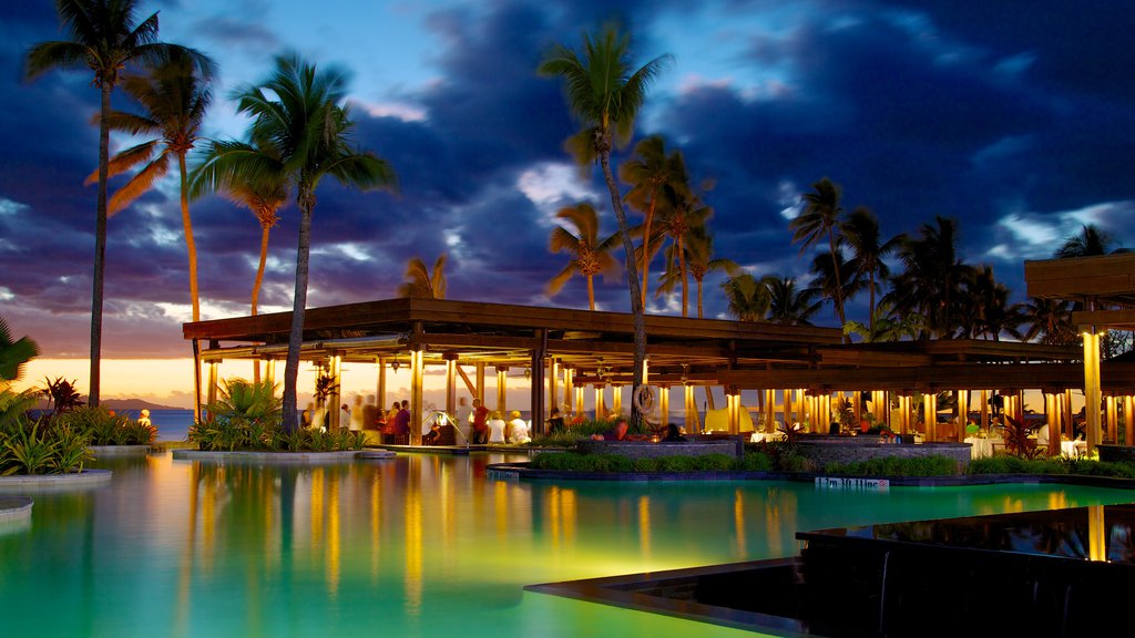 Fiji which includes night scenes, a luxury hotel or resort and a sunset