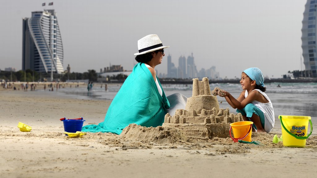 Parque y playa de Jumeira Beach mostrando una playa y también una familia