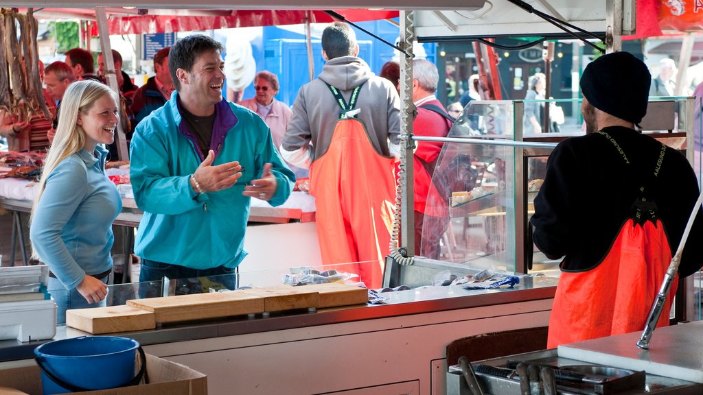 Torget Fishmarket showing markets as well as a small group of people