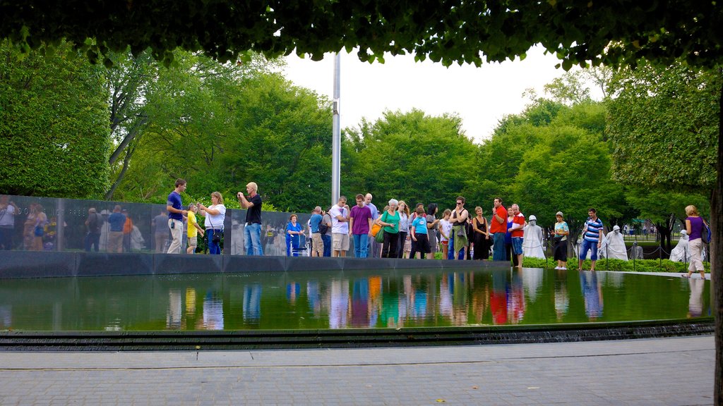 Korean War Veterans Memorial showing a memorial and a pond as well as a large group of people