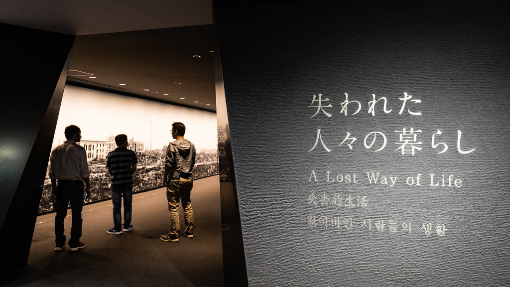 Museo de la Paz de Hiroshima ofreciendo señalización y vista interna y también un pequeño grupo de personas