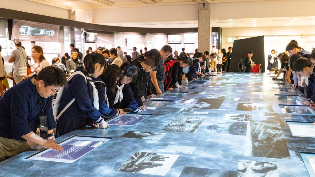 Museo de la Paz de Hiroshima mostrando vistas interiores y también un pequeño grupo de personas