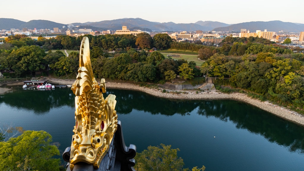 Okayama-kasteel inclusief een rivier of beek en landschappen