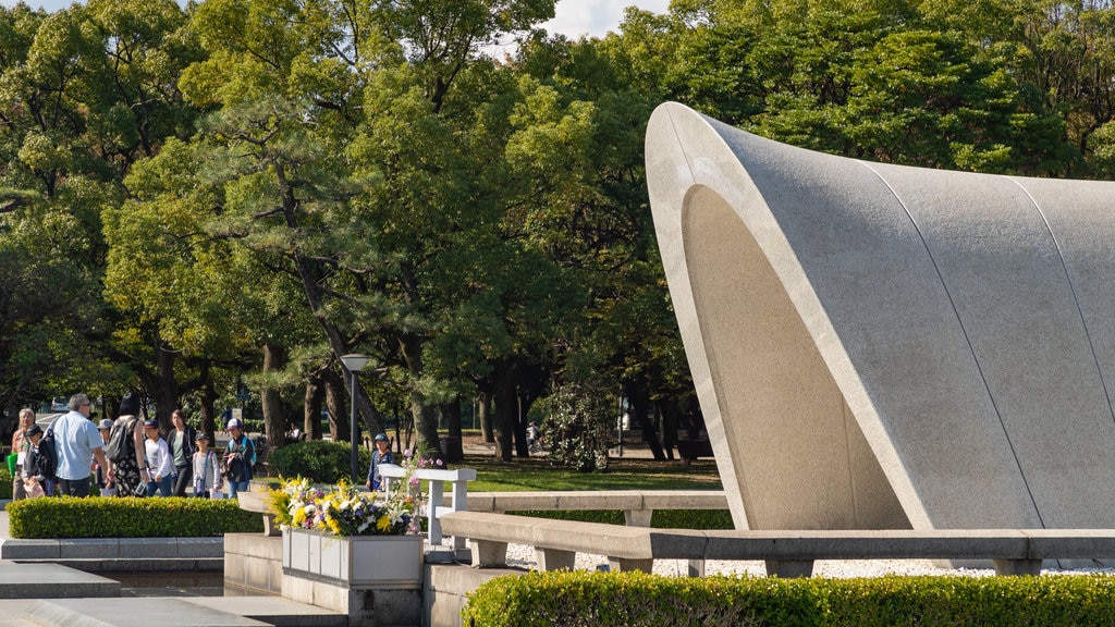 Cenotafio en honor de las víctimas de la bomba atómica mostrando flores y un parque