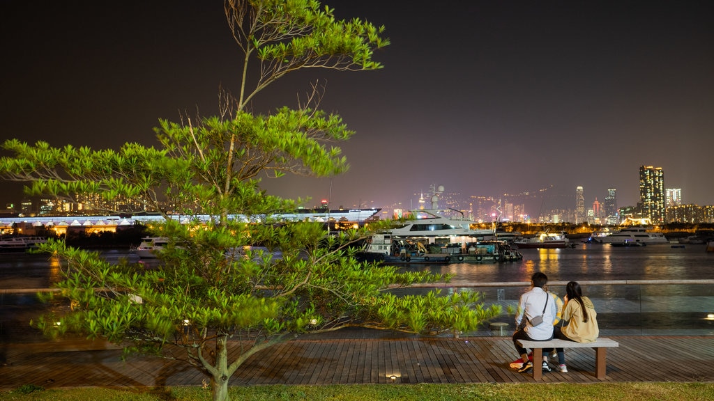 Calçadão de Kwun Tong caracterizando cenas noturnas e uma baía ou porto assim como um casal