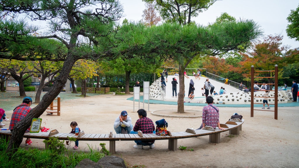 Gyosen Park featuring a playground and a garden as well as a family