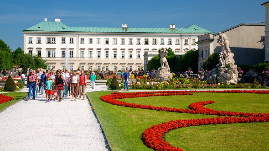 Mirabell Palace and Gardens featuring a statue or sculpture, flowers and château or palace