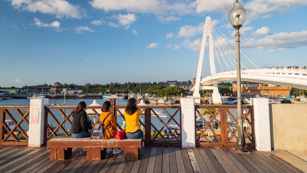 Tamsui Fisherman\'s Wharf showing a bay or harbour as well as a small group of people