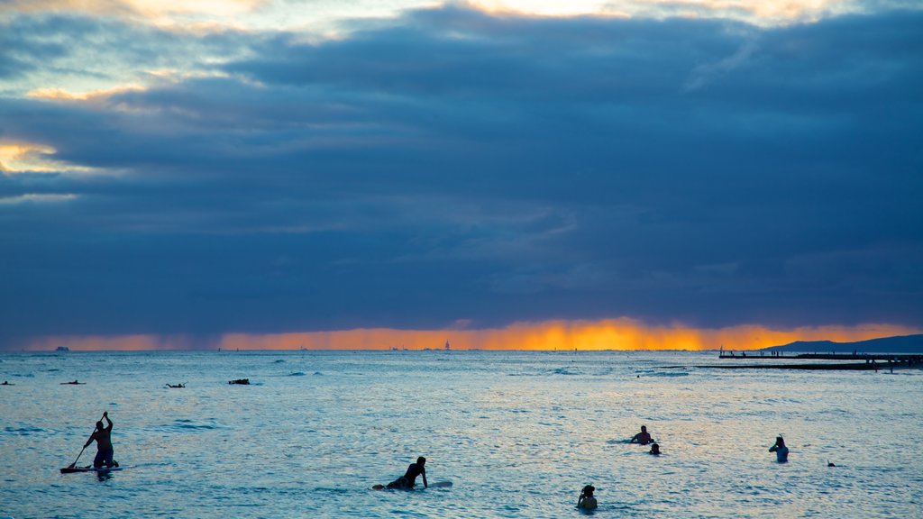 Waikiki Beach som omfatter udsigt over kystområde, surfing og en solnedgang