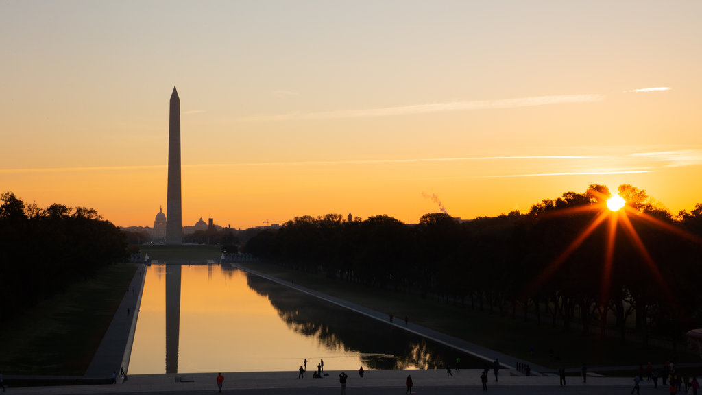 Lincoln Memorial montrant un monument, un lac ou un point d’eau et un coucher de soleil