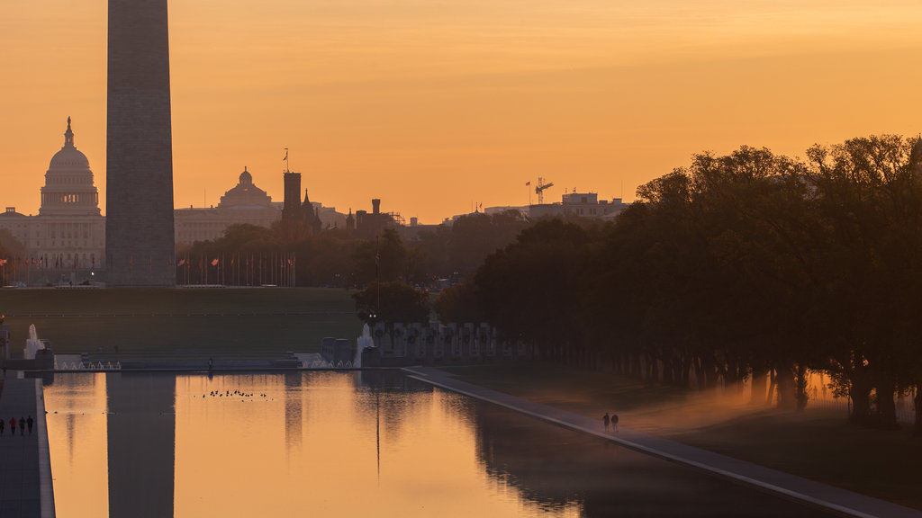 National Mall which includes a park, mist or fog and a sunset