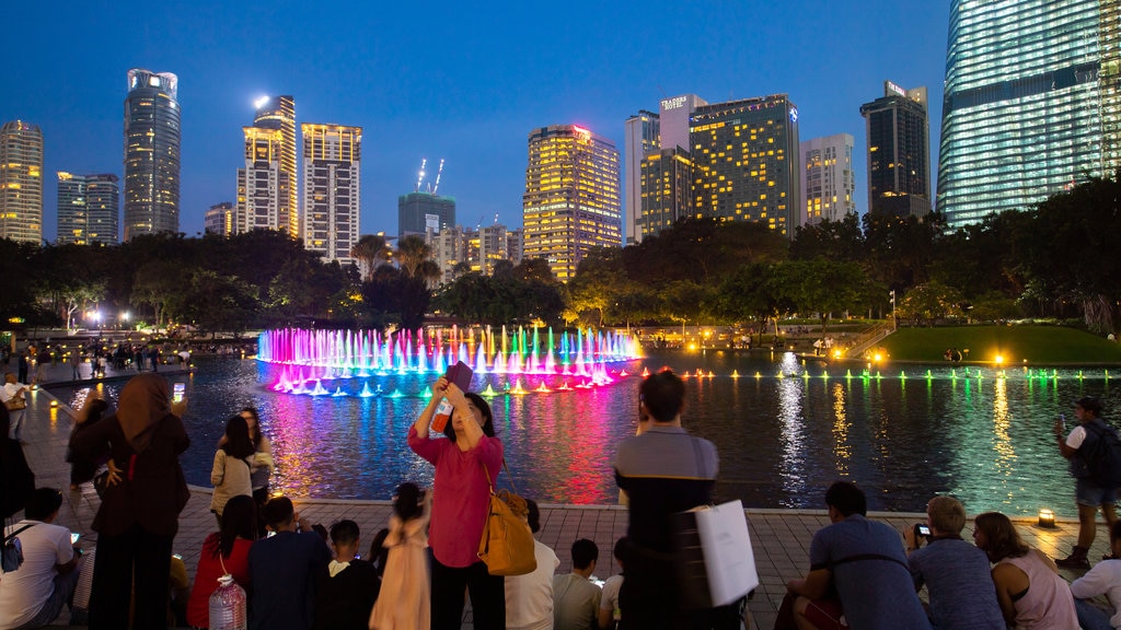 Parque KLCC mostrando escenas de noche, una fuente y una ciudad