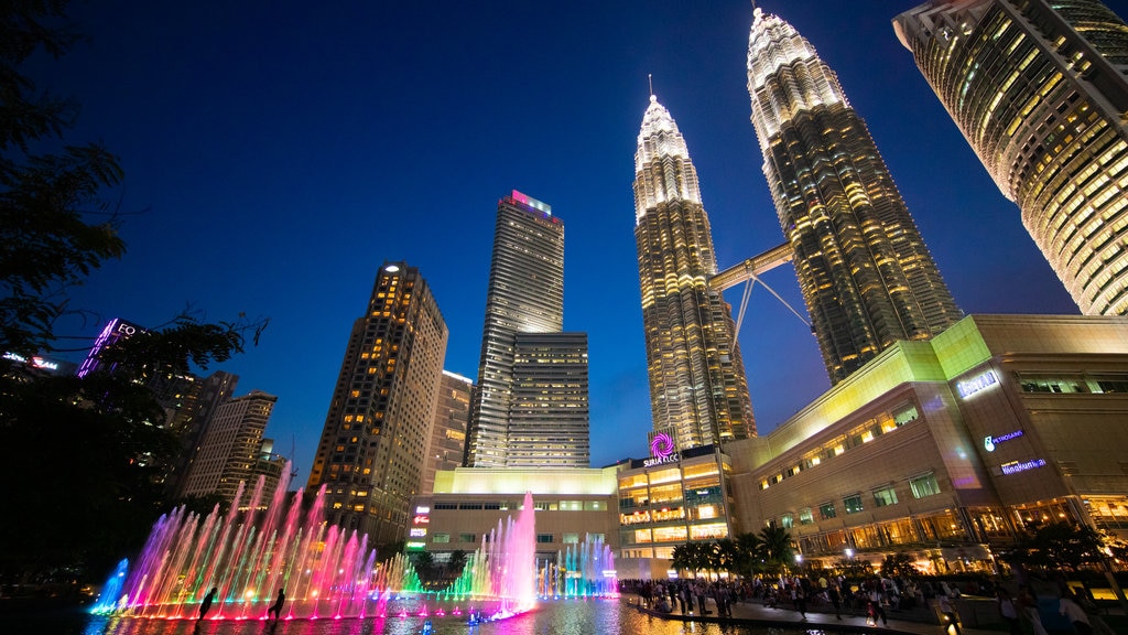 KLCC Park que inclui cenas noturnas, uma fonte e um arranha-céu