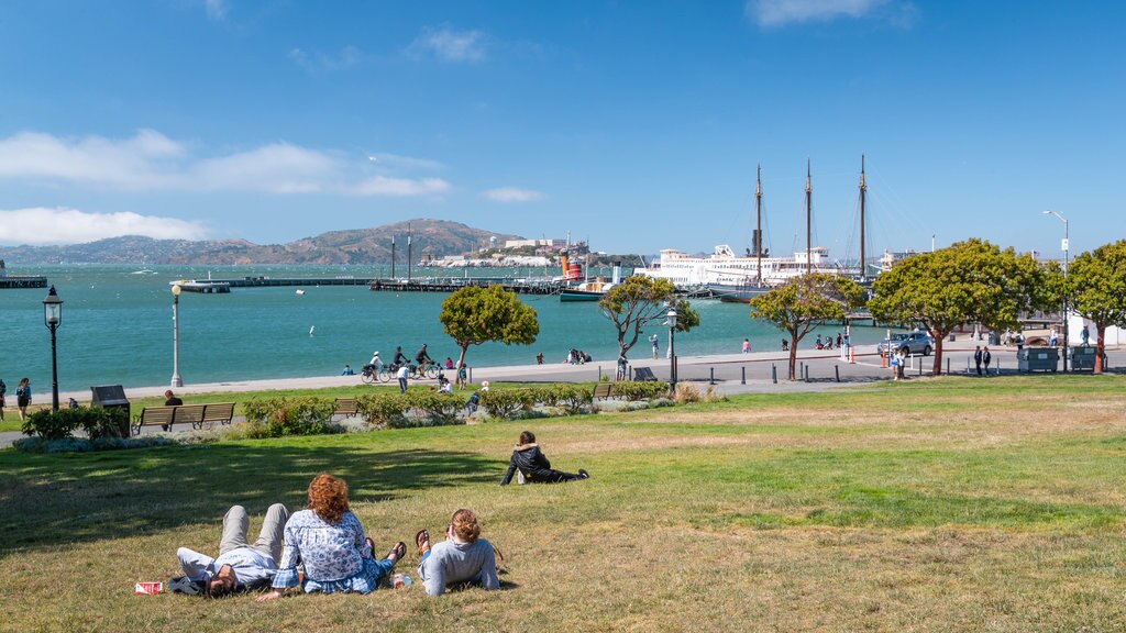 Parque Histórico Nacional Marítimo de San Francisco ofreciendo un jardín y vistas generales de la costa y también un pequeño grupo de personas