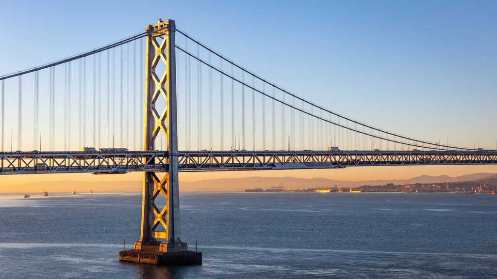 Puente de la Bahía mostrando un atardecer, un puente y una bahía o un puerto