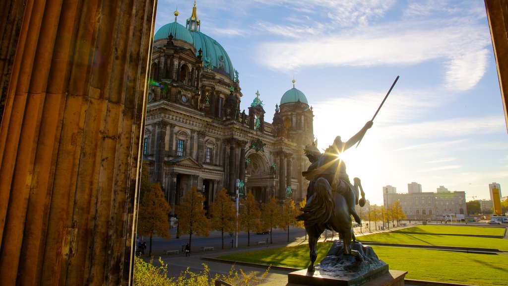 Berlín ofreciendo un parque, un atardecer y una estatua o escultura